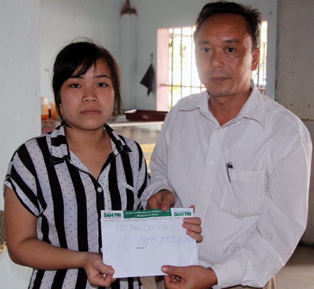 Ông Nguyễn Công Chúc - Phó chánh Văn phòng UBND huyện Yên Thành trao quà bạn đọc tới em Bùi Thị Chiên.