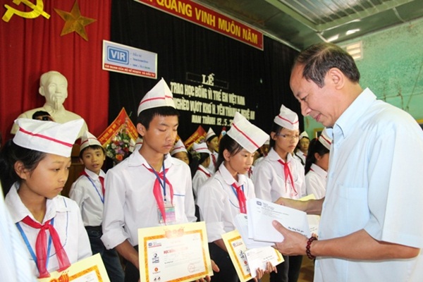 Thiếu tướng: Đặng Trọng Huy trao quà cho các em học sinh.