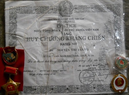 Nữ thanh niên xung phong Nguyễn Thị Lương và huân - huy chương, giấy chứng nhận thành tích của bà.     Ảnh: Lê Tập